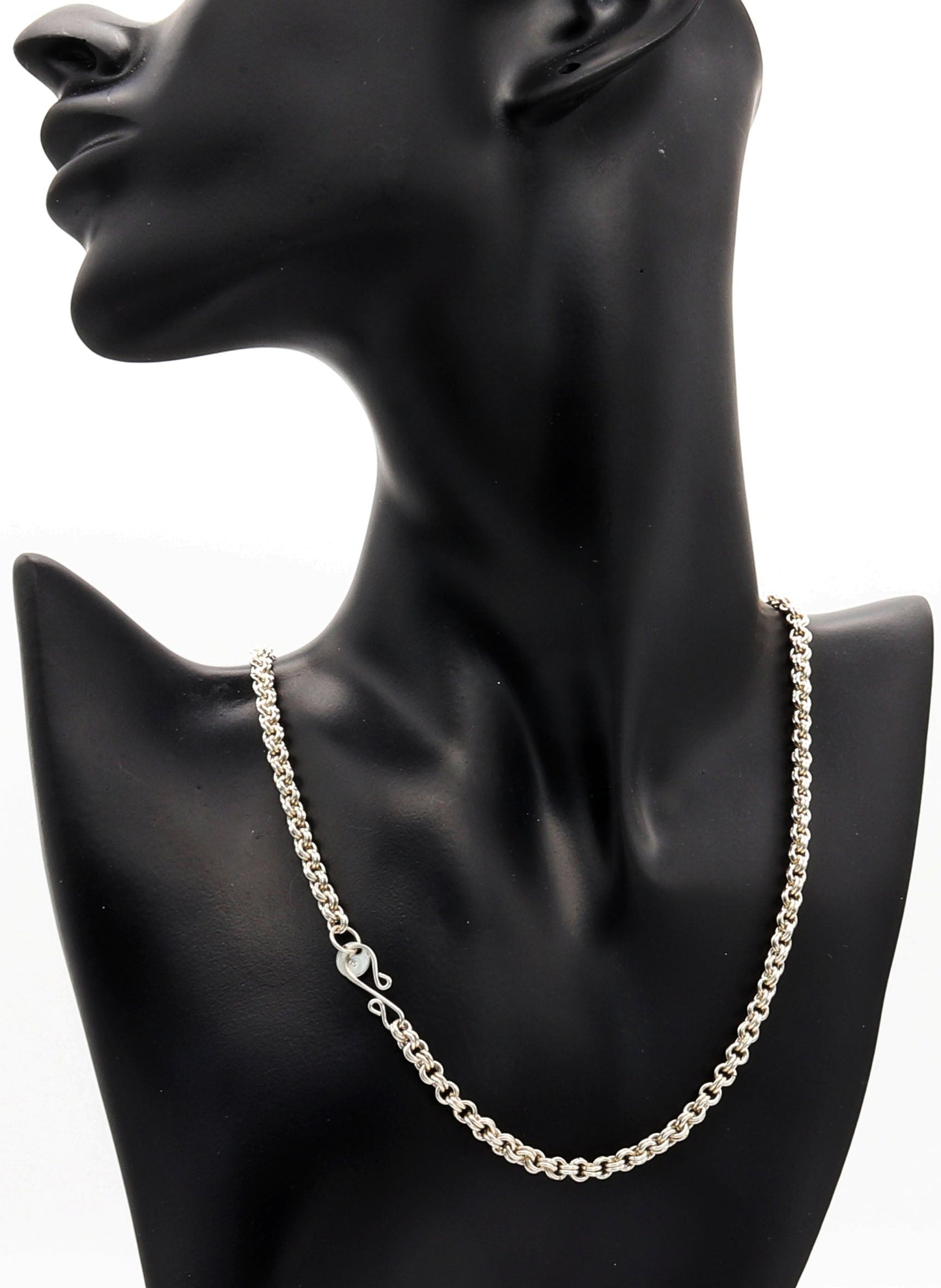 Silver chain necklace on a black mannequin bust against a white background