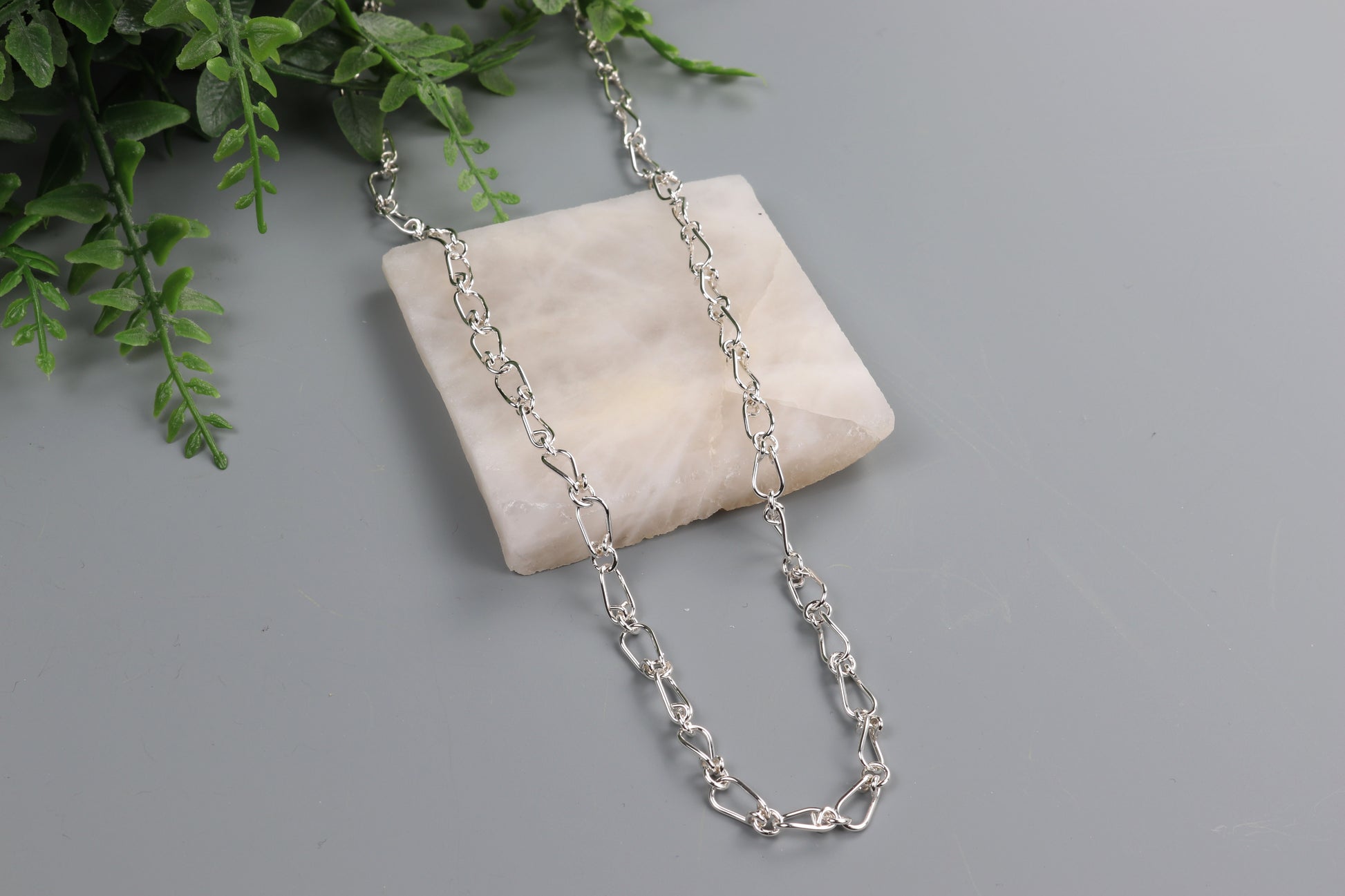 Argentium Silver Teardrop Chain Necklace, shown against light gray background draped over white stone slab.