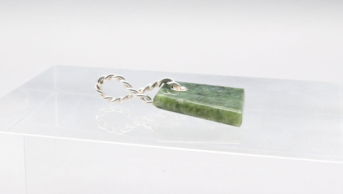 Side view of Wyoming Jade Pendant shown on light gray background.