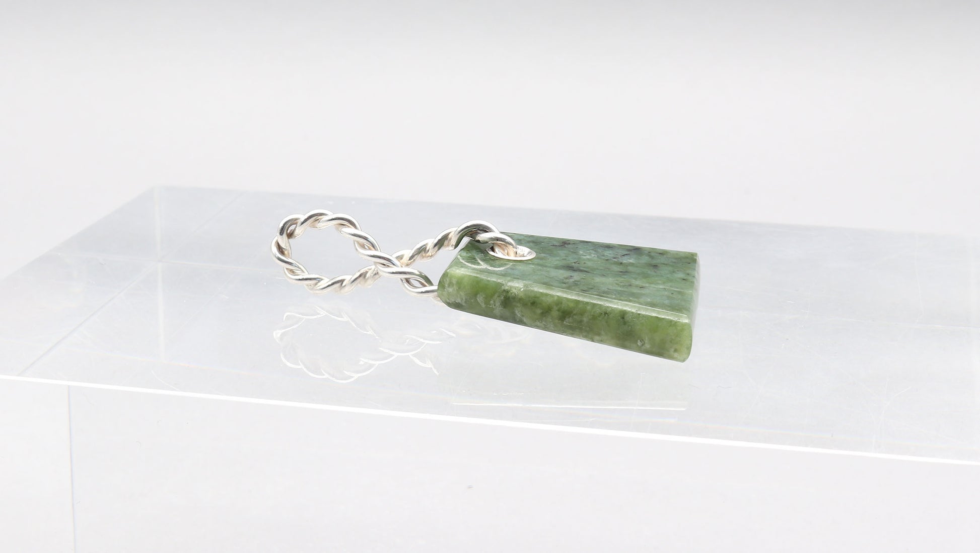Side view of Wyoming Jade Pendant shown on light gray background.