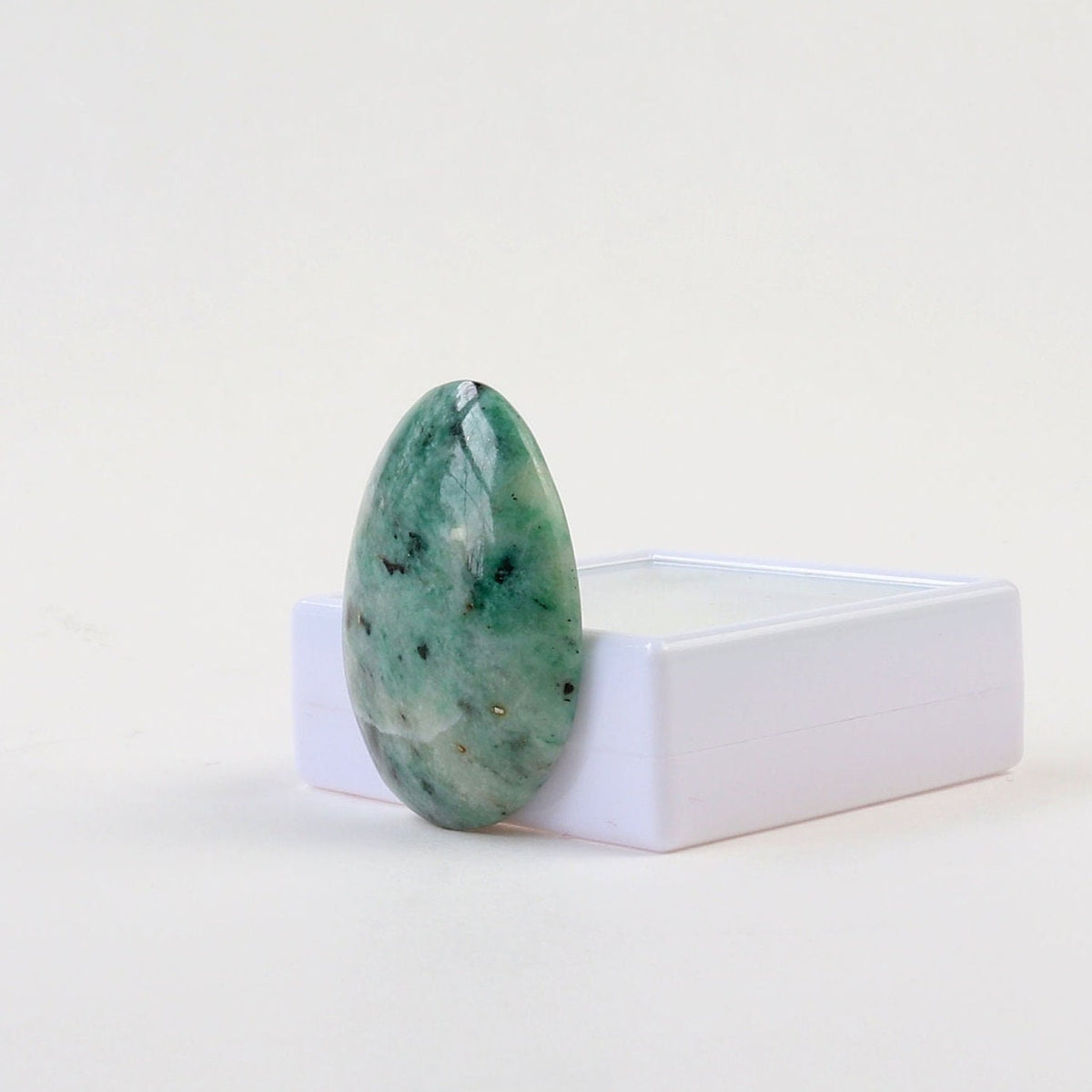 Hand-cut African Turquoise Jasper teardrop cabochon with natural teal-green, cream, and dark mineral patterning shown at right angle on a white background