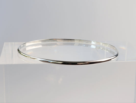 A side view of the silver bangle bracelet with a smooth, polished finish.