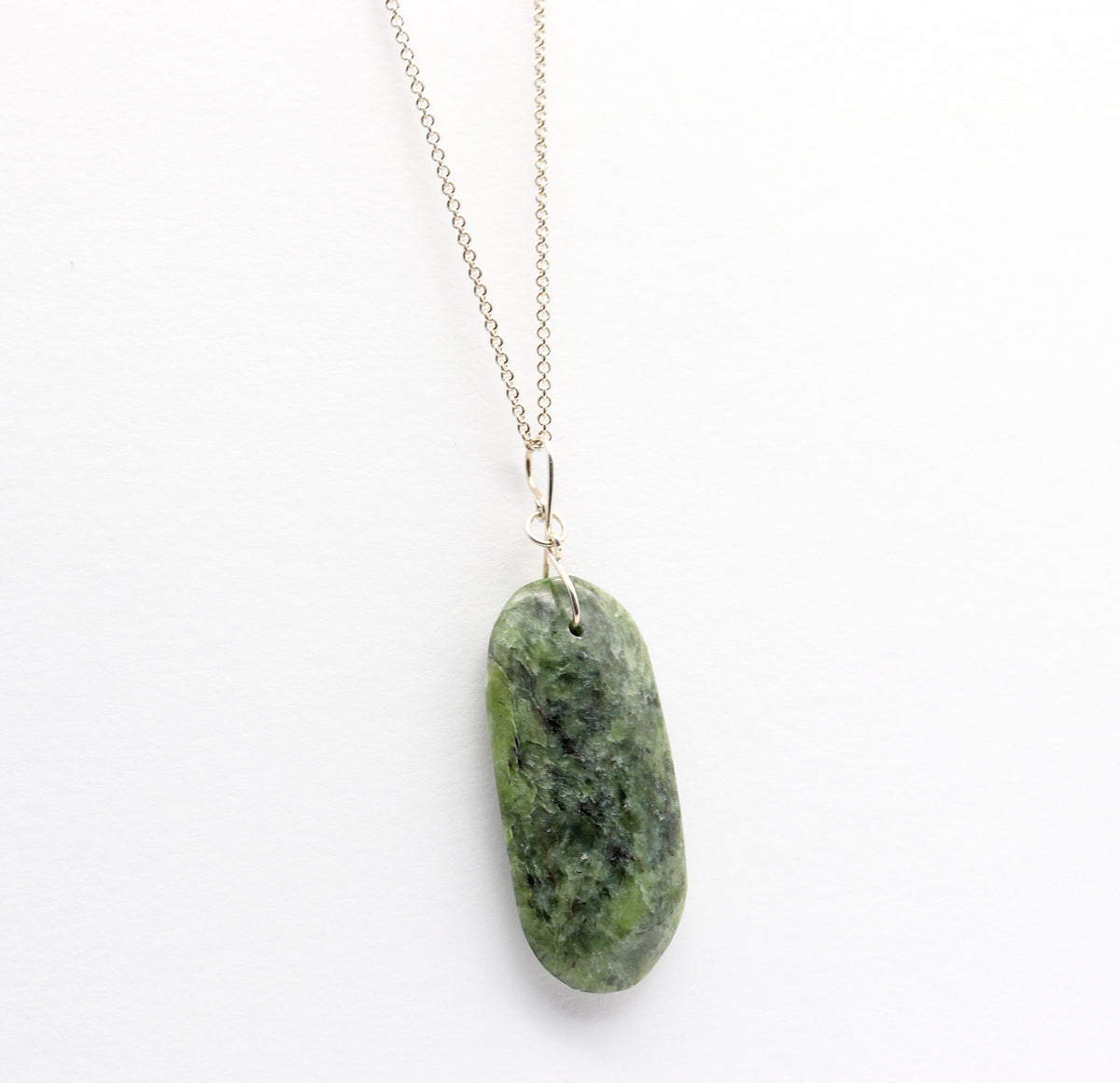 A Wyoming Jade polished stone pendant necklace on a delicate Argentium chain, displayed against a clean white background.