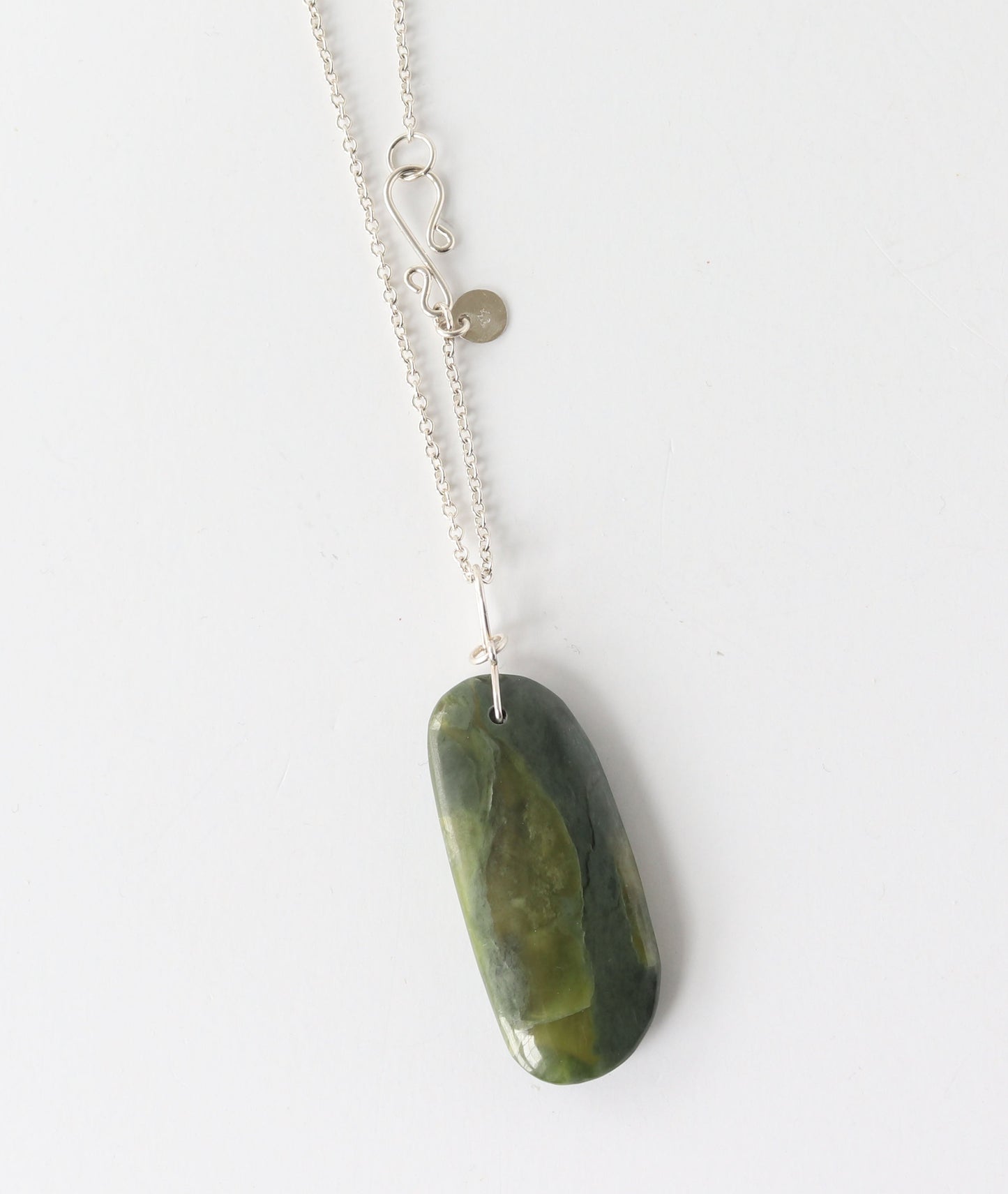 A silver chain necklace with a polished California jade stone pendant, photographed against a plain white background.