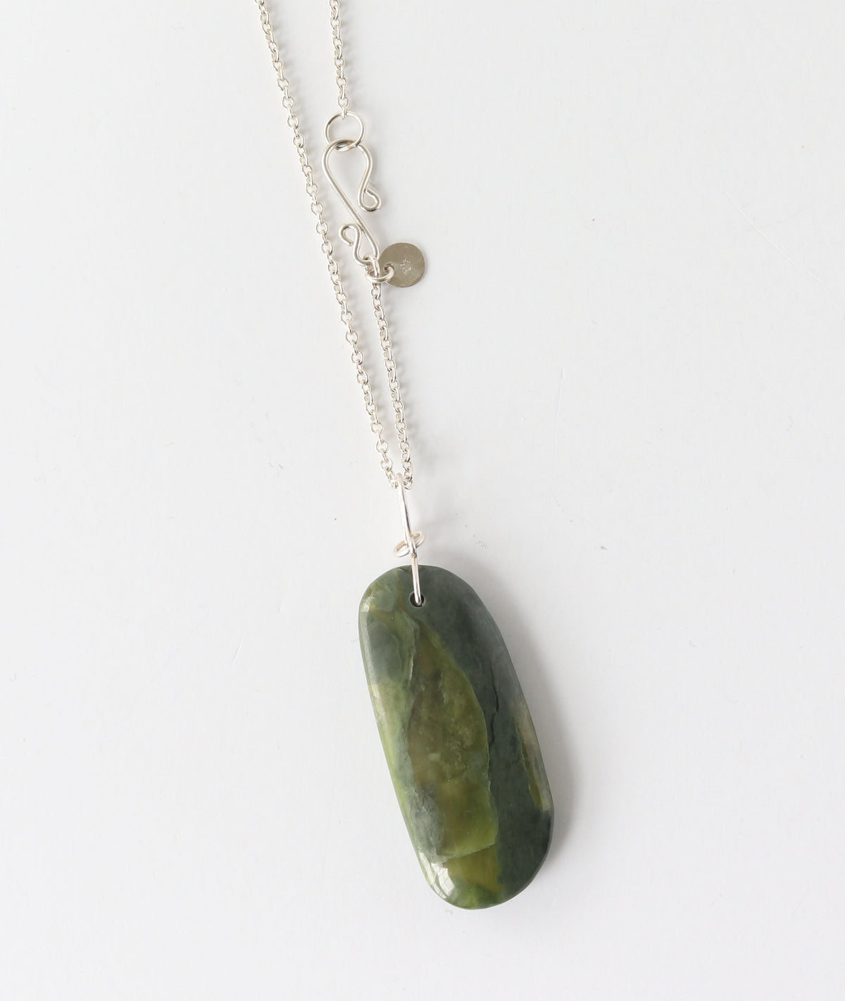 A silver chain necklace with a polished California jade stone pendant, photographed against a plain white background.