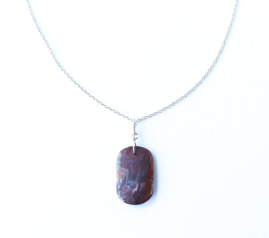 A Red Mexican Agate pendant features layered shades of warm red, burgundy, muted mauve, soft gray, and cream, with natural banding.  handcrafted infinity bow-style bail in solid Argentium® 935 Silver and paired with our handcrafted 1.9 mm Argentium® Silver chain necklace