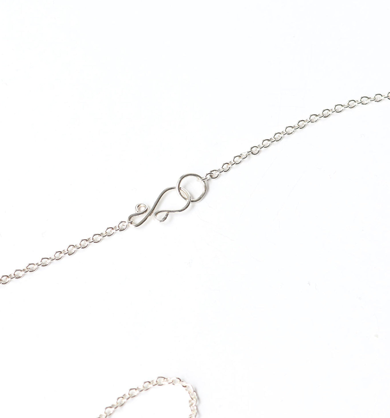 Argentium Silver chain necklace with closeup of custom S-Hook clasp on a white background