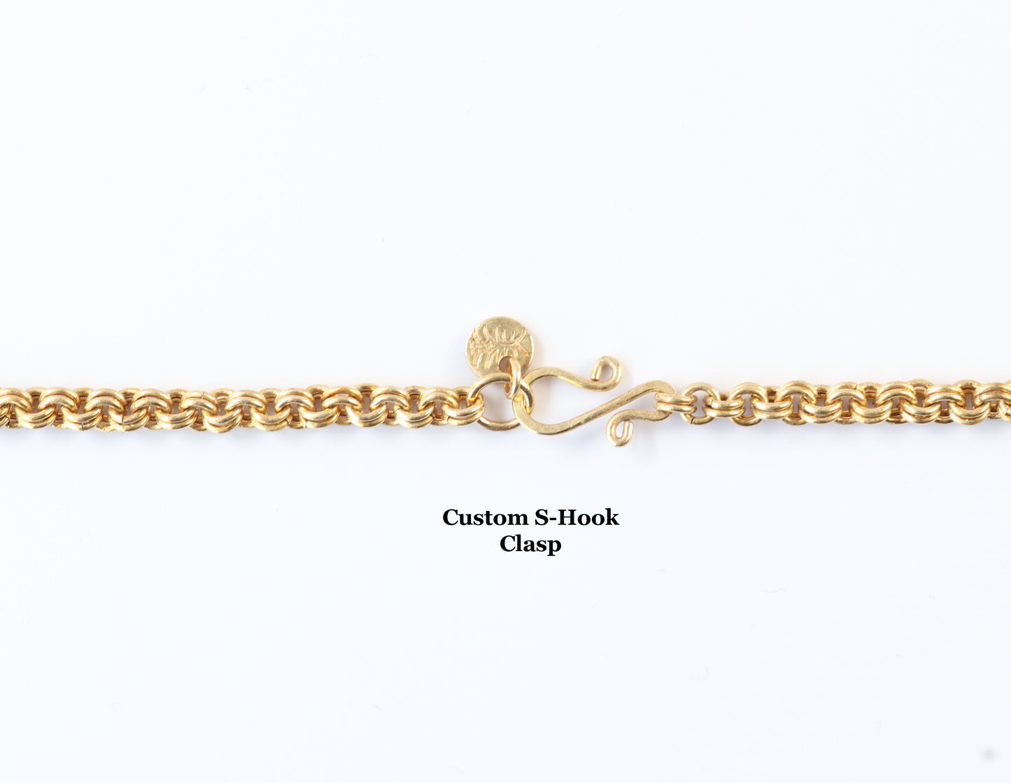 A handmade brass double link chain featuring a true double-to-double ring weave that offers both strength and fluid drape.  Shown on white background a close-up of the vintage-style S-hook clasp, this design makes an excellent base for your own pendants, charms, or custom jewelry creations.