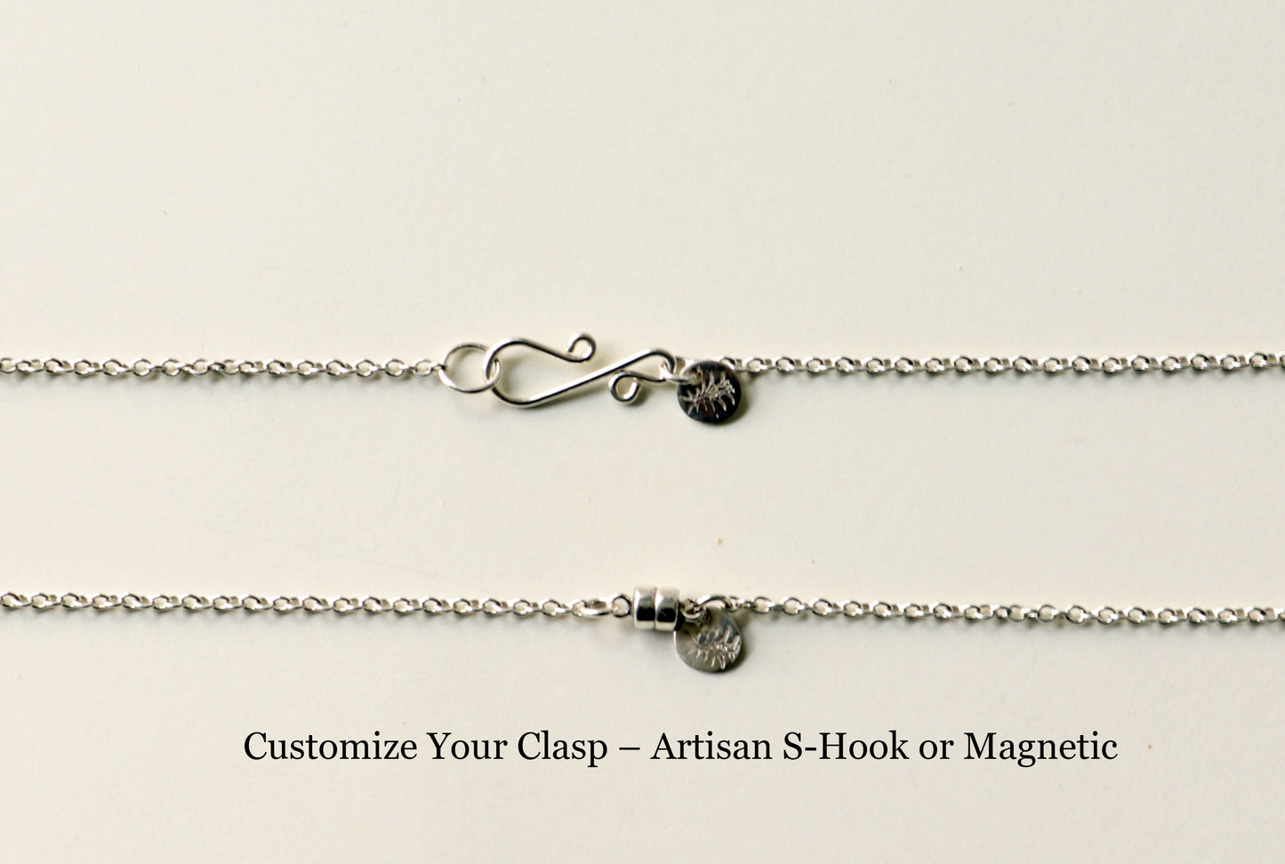 Close-up of a necklace with clasp options on a light gray background
