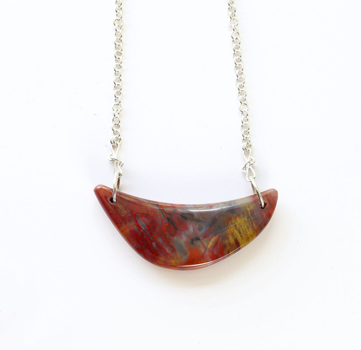 Argentium Necklace with a Petrified Rainbow wood crescent pendant on a white background