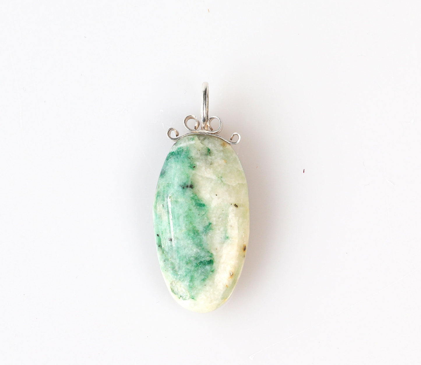 African Turquoise Jasper pendant handcut polished on both sides for a reversible design. The stone reveals captivating hues of green and cream, reminiscent of natural turquoise, yet with its own distinct charm.  Set in a handcrafted bow-shaped bail made from tarnish-resistant Argentium® 935