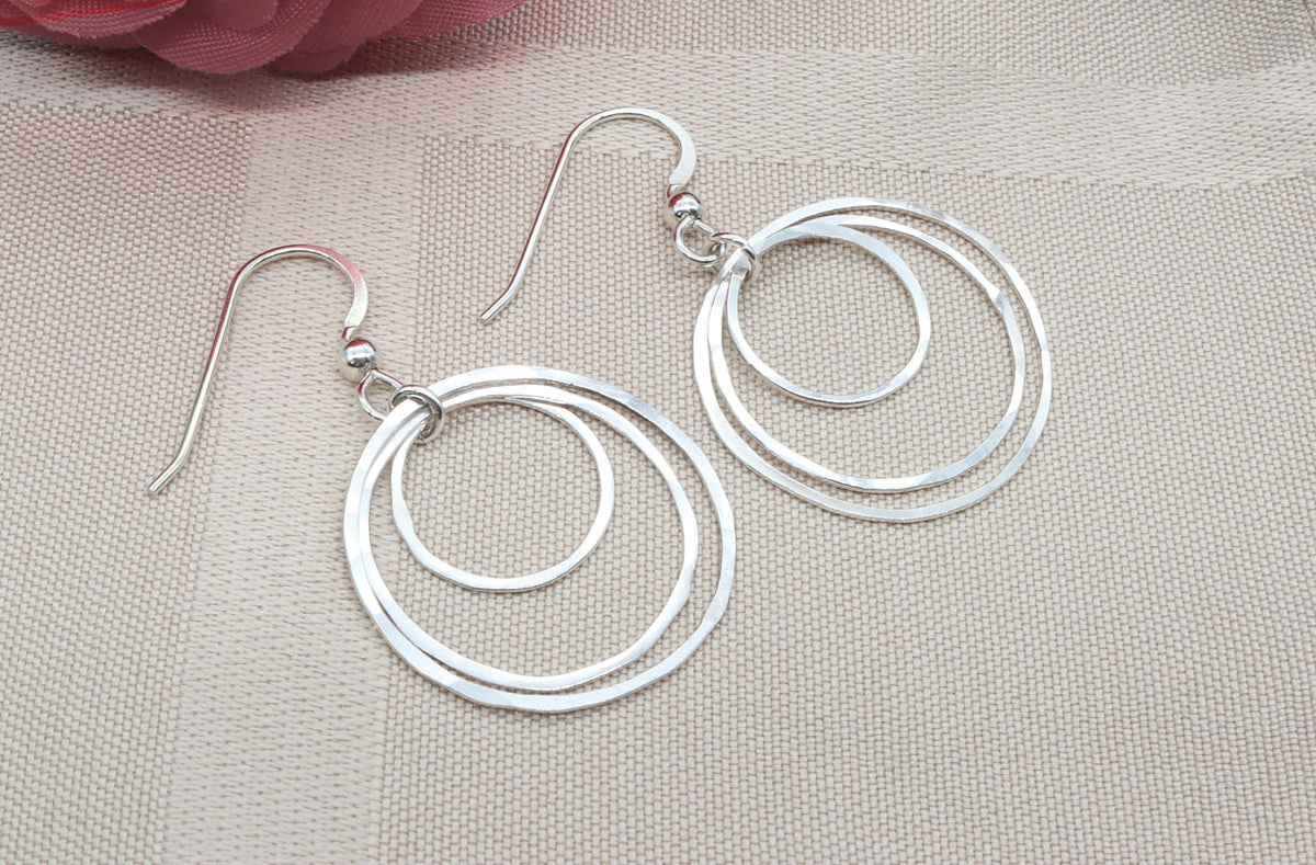 Argentium Silver hoop earrings on a beige fabric background