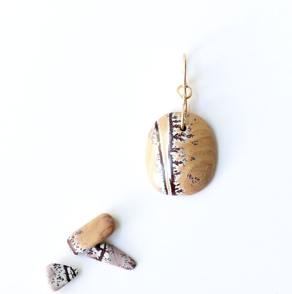  Sonoran Dendritic Rhyolite cabochon pendant., displayed on a clean white background next to three small Dendritic flat stones for scale and props.