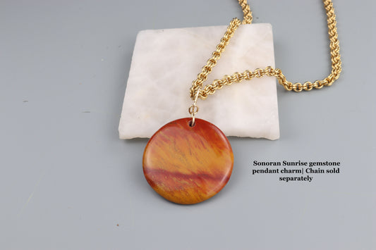 Jewelry with a Sonoran Sunrise gemstone pendant on a gray background