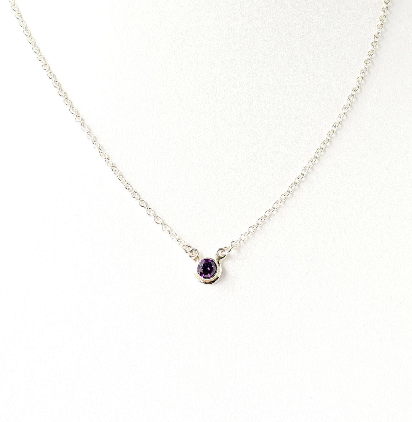 A dainty 5mm purple gemstone pendant necklace set in Argentium silver shown on white background. 