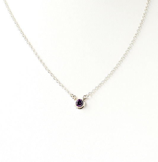 A dainty 5mm purple gemstone pendant necklace set in Argentium silver shown on white background. 