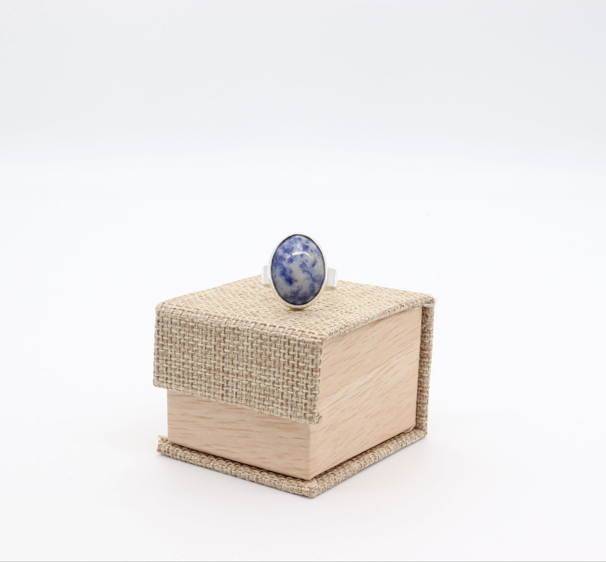 Natural Brazilian Blue Sodalite ring handcrafted in Argentium 935 silver, size 9 shown on gift box against white background.