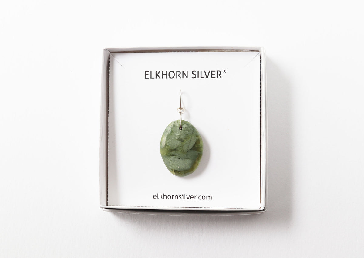 A California jade polished stone pendant displayed in a jewelry box on a white backing card, with the brand name ELKHORN SILVER printed at the top.