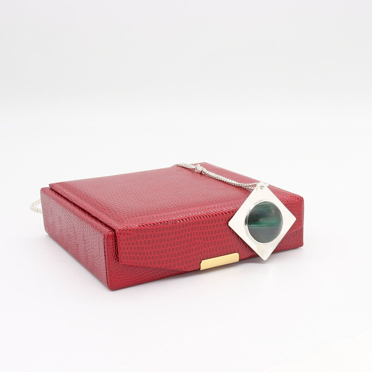 Handcrafted malachite pendant necklace in Argentium silver with geometric setting shown against a Red gift box against a white background.
