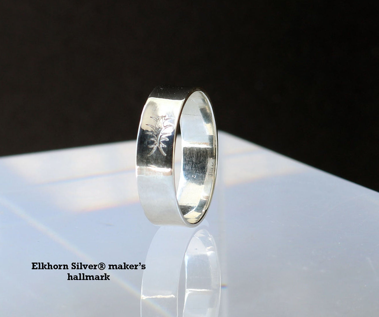 Argentium Silver ring on a reflective surface with a black background