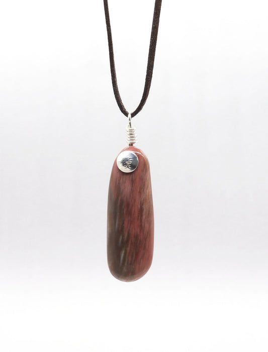 A dark brown leather cord necklace featuring a polished reddish-brown Petrified Wood Pendant pendant with natural grain and a silver-colored metal cap.  Shown against a light gray background.