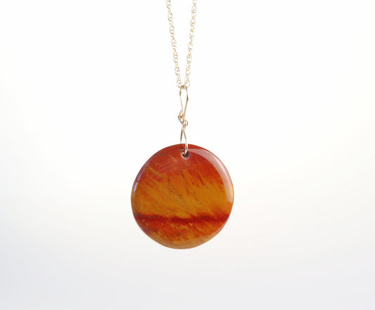 Shown on white background is this one-of-a-kind Sonoran Sunrise pendant, hand-cut and polished to highlight the rich red and golden tones of cuprite-dominant stone.  Finished with a handcrafted 14/20 gold-filled infinity bow bail, this pendant is ready to wear with your favorite chain or use as a striking focal piece in your own jewelry design.