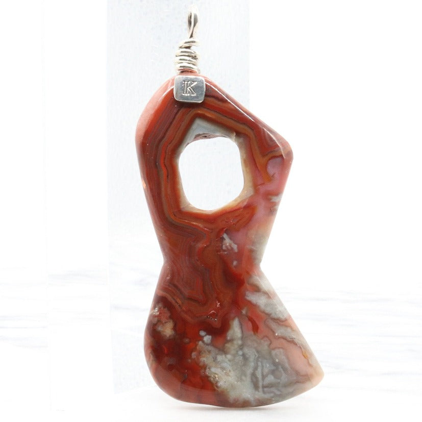 A natural Crazy Lace Agate Gemstone pendant necklace showcases the mesmerizing beauty of nature's art. Handcut and freeform polished to showcase the unique swirling patterns and vibrant reds, pink and gray hues of the Crazy Lace Agate gemstone.&nbsp;