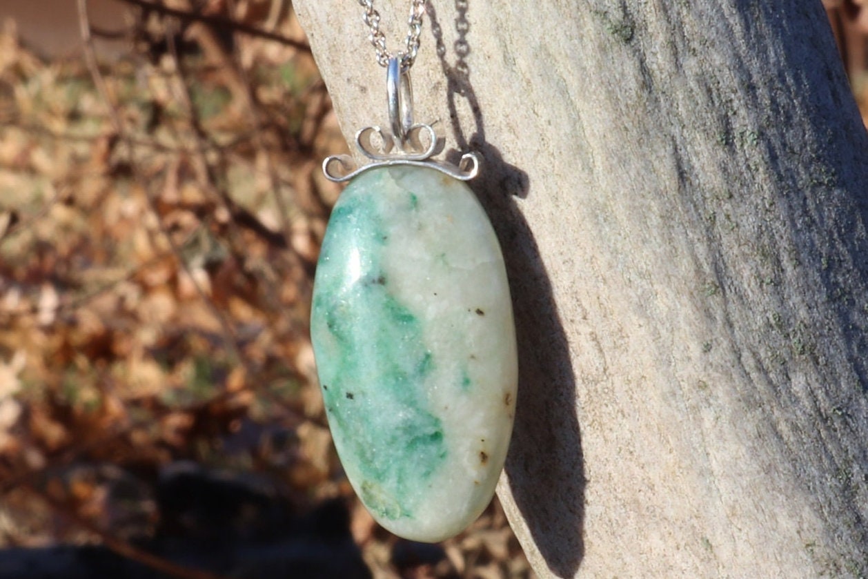 Lovingly handcrafted in our Missouri, USA studio is this natural 1.81 inch African Turquoise Jasper reversible pendant. Handcut and freeform polished to reveal the unique shades of green and cream hues crafted with a premium bow-shaped wire bail in sterling 935 Argentium silver plus a complementary sterling 935 Argentium chain ensuring both style and longevity.