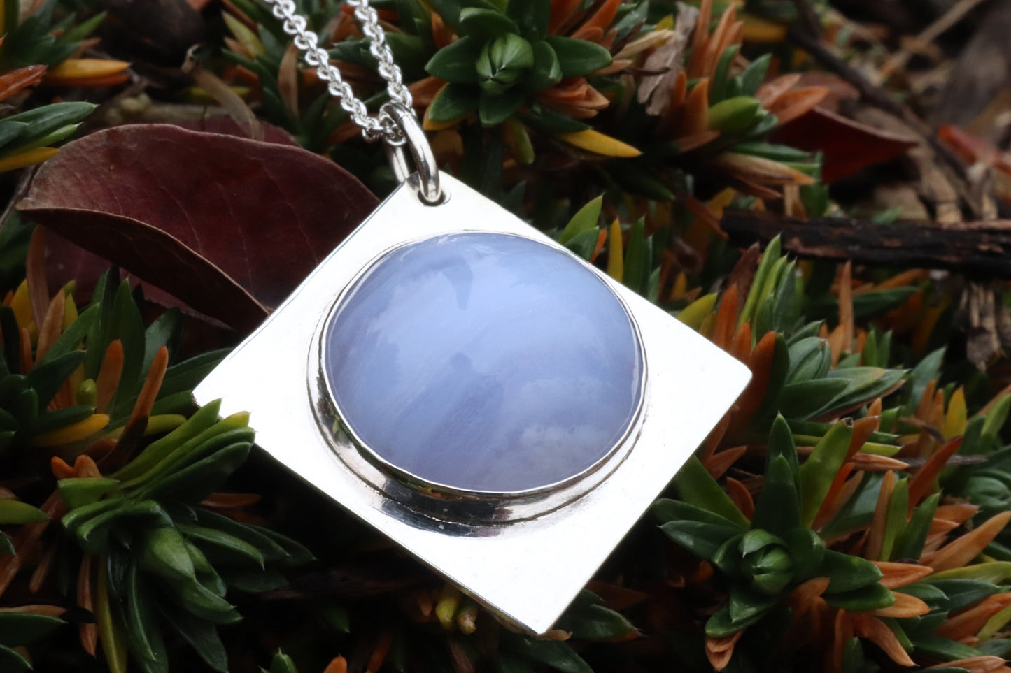 An authentic, high-quality Blue Lace Agate Cabochon, handcrafted in our Missouri USA studio and set within a custom four-point diamond shaped sterling Argentium 935 Silver, and to complete the look a complementary 18" premium silver chain is included.