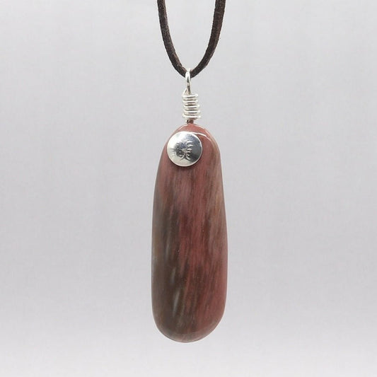 A handcut and freeform polished Arizona Petrified Rainbow Wood gemstone pendant. The petrified rainbow wood pendant displays one-of-a-kind colors, shapes, and patterns, making it truly special.
The custom sterling Argentium 935 Silver is made from 100% recycled silver, offering both beauty and resistance to tarnis