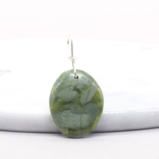 A 1.93 inch California Jade gemstone pendant. Handcut and polished to showcase its unique translucent qualities, green hues and striking patterns on both sides. The pendant is designed with an original infinity bow shaped wire bail made from sterling Argentium® 935 Silver that is tarnish resistance and has a remarkable shine. The complete the look a complementary 935 Argentium silver chain is included.
