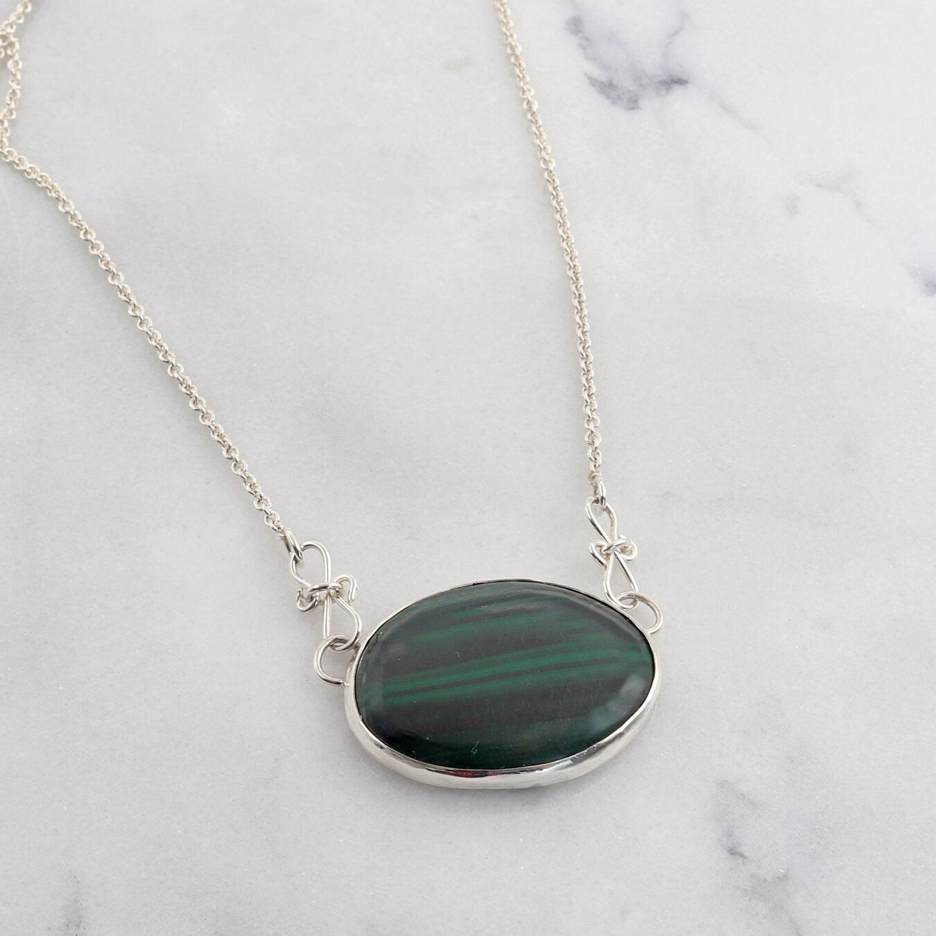 A unique Malachite gemstone pendant hand-cut and polished stone and set in solid sterling 935 Argentium® Silver. Designed with a custom chain and S hook for easy wearability.