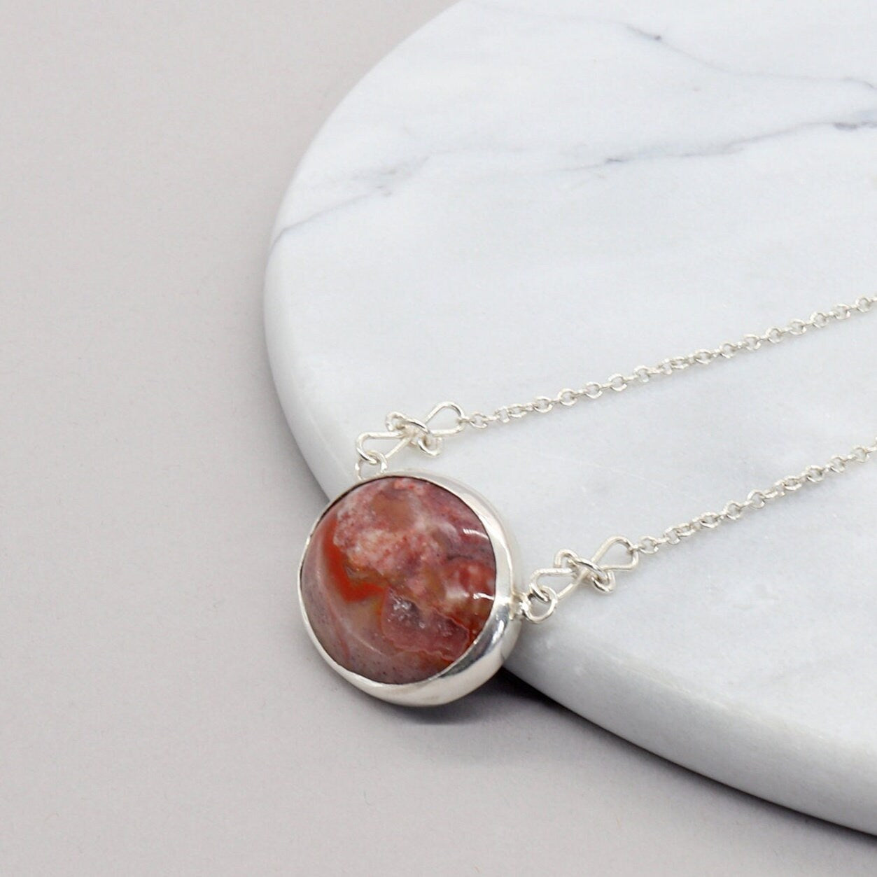 This unique Jasper gemstone was found in the Yellowstone River during a hike in Montana. It has been hand-cut and polished in our Missouri USA studio and set in a handcrafted solid sterling Argentium® 935 Silver bezel paired with an attached crafted custom chain with custom shepherd's hook clasp, resulting in a one-of-a-kind statement Necklace.