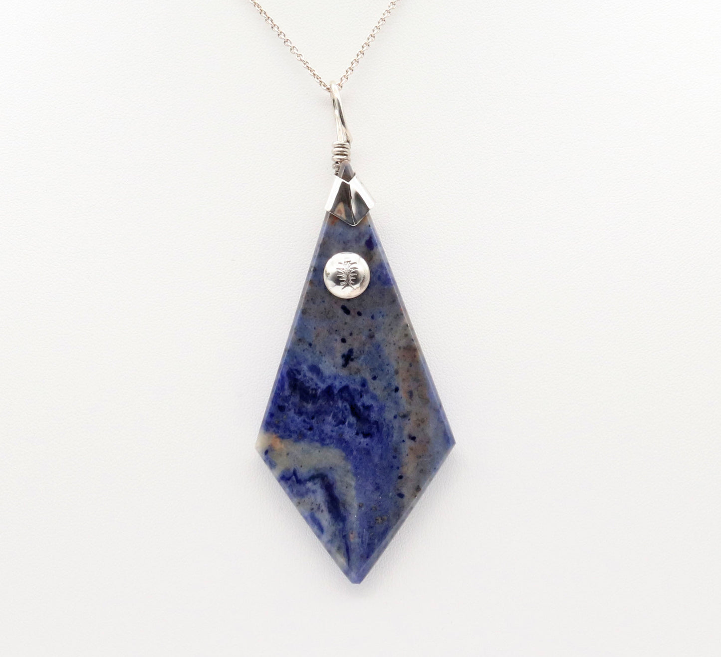 A 3.23 inch distinctive, rare and remarkable Foidolite igneous rock, expertly cut into a kite shape, polished, and elegantly presented with a custom crafted Argentium® Silver bail setting.