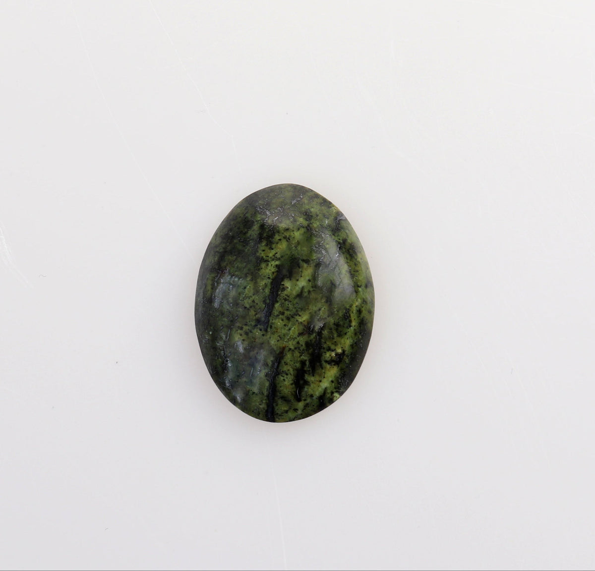 A small oval Forest Green Jasper cabochon gemstone with a dark green and black marbled pattern, centered on a plain white background.