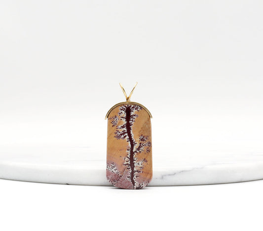 Sonoran Dendritic Rhyolite Pendant – Brass Bail shown against white marble with text overlay Dendritic Patterns - Tan Pink Charm shown on light gray background.