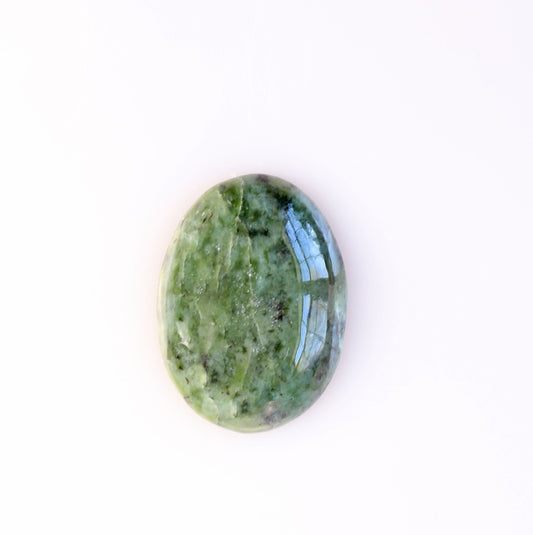 Hand-cut oval Wyoming Nephrite Jade cabochon with natural green tones and dark mineral patterning shown on plain white background.