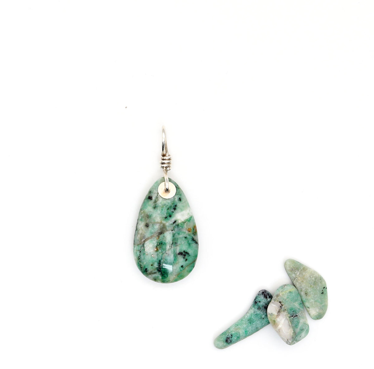 African Turquoise Jasper Pendant teardrop-shaped handcut polished on both side with black and white patterns.  A custom silver bail is in Argentium silver.  Shown on white background with raw turquoise jasper pebbles as props.