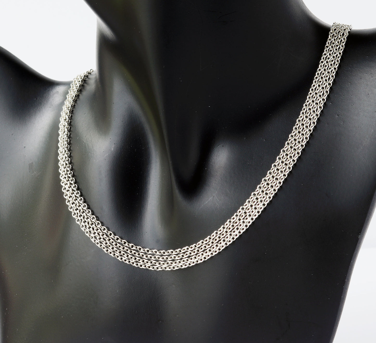 Silver chain necklace on a black mannequin