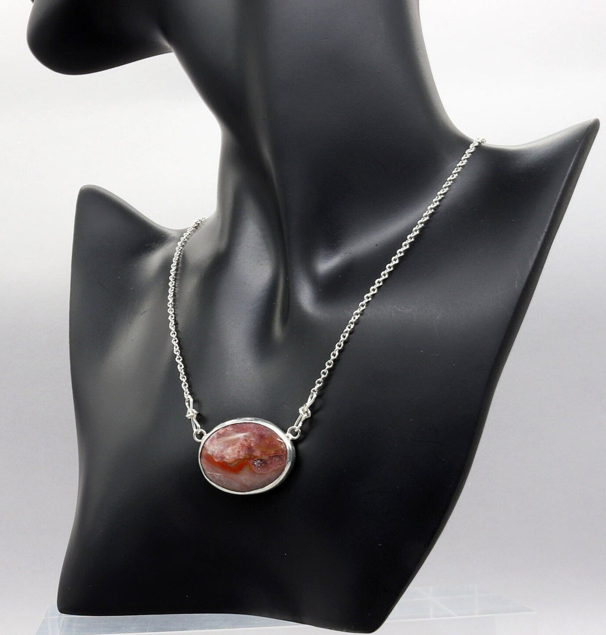 Natural Montana Jasper necklace handcrafted in Argentium 935 Silver with attached silver chain shown on black resin jewelry form.