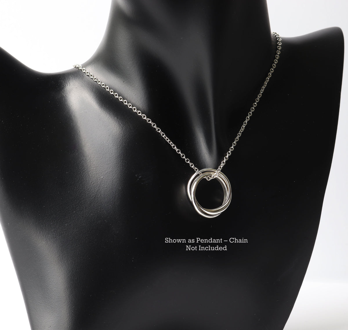 Handcrafted solid sterling silver rolling ring with three interlocking polished bands shown on black resin jewelry form with Argentium chain for styling inspiration. Text reads 'Shown as Pendant-Chain Not Included'