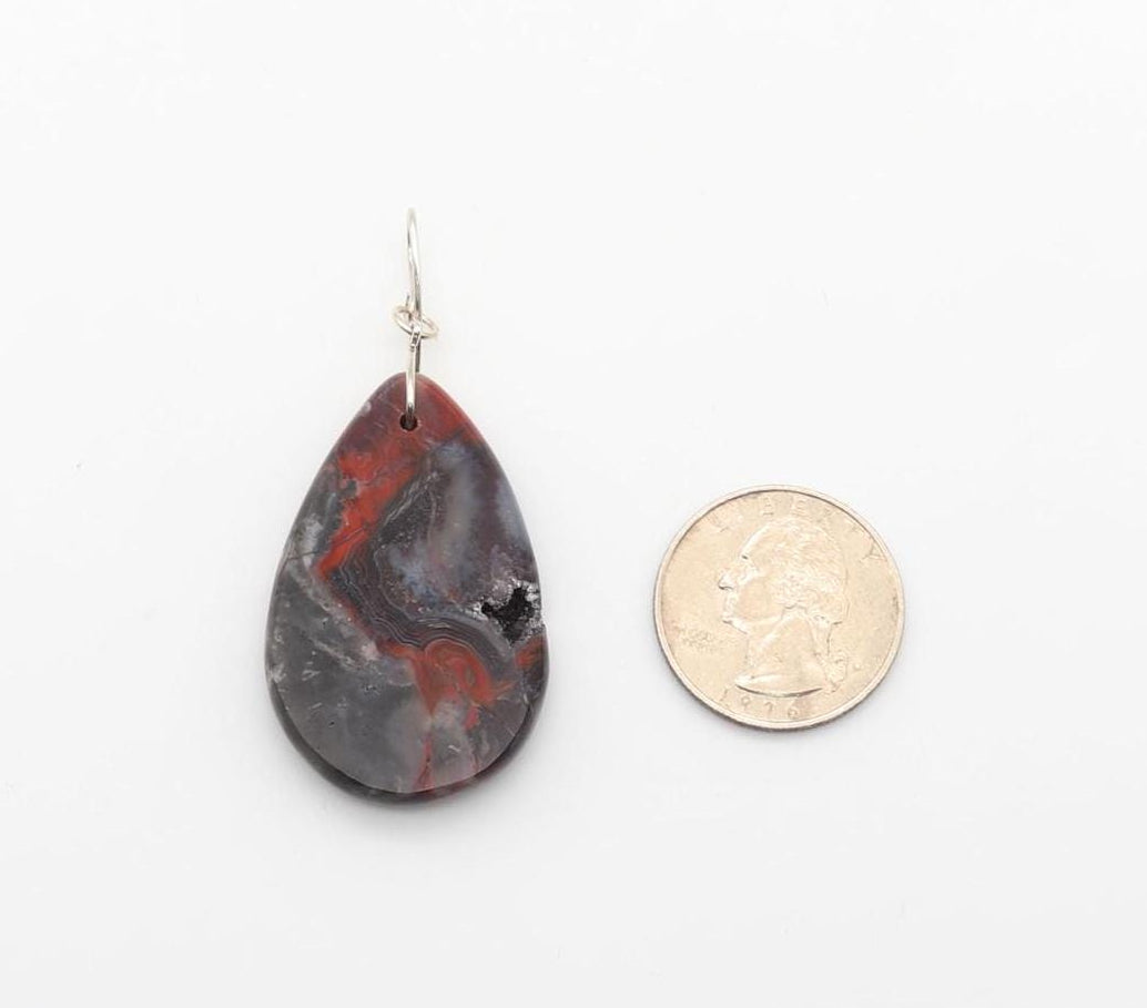 Natural Mexican Red Agate druzy teardrop pendant with Argentium 935 Silver bail shown next to U.S. quarter for scale.
