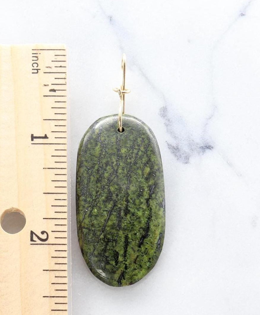 Forest Green Jasper pendant shown on white marble next to ruler for sizing perspective.