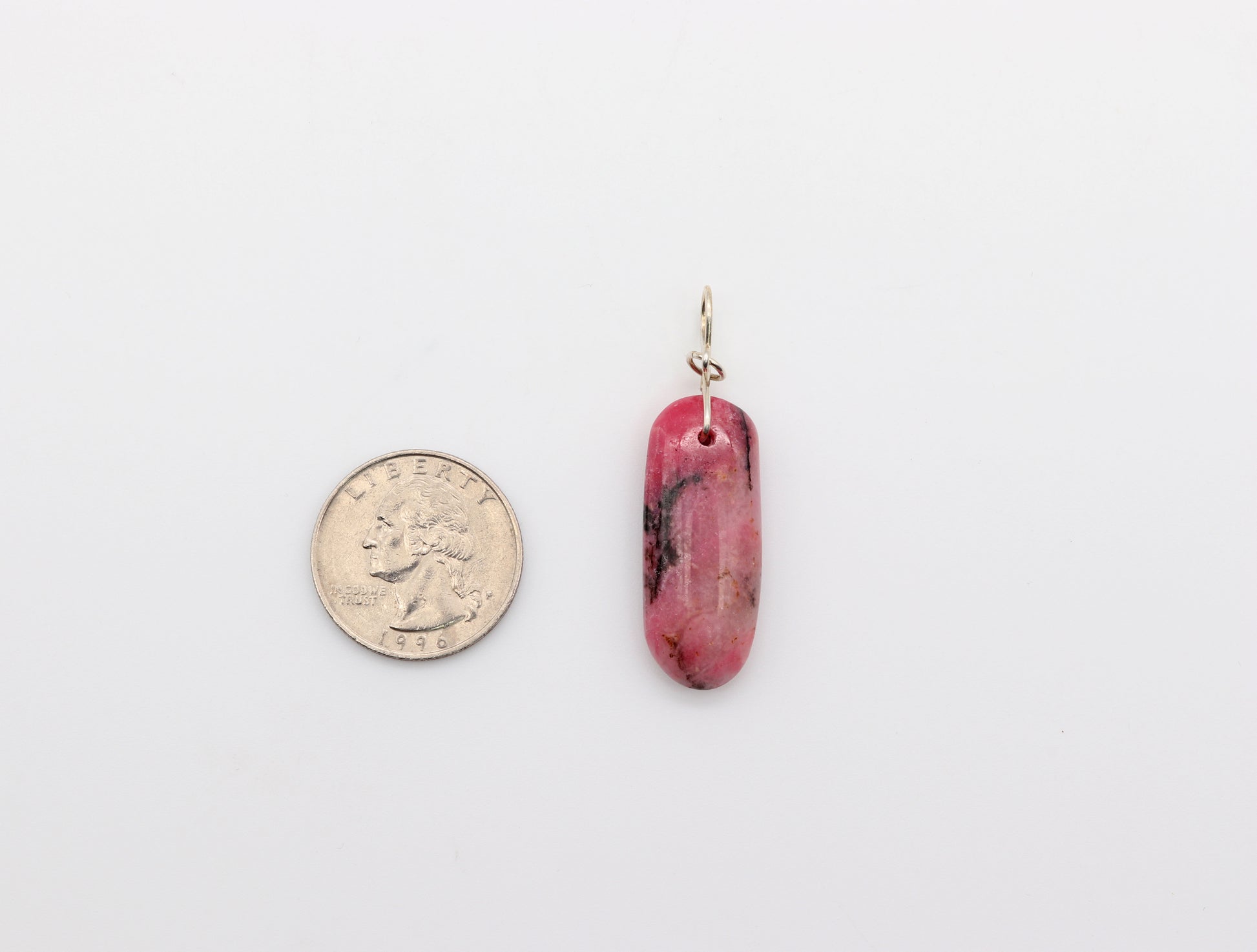 This 1.79 inch Pendant is. shown next to quarter for scale. natural pink Rhodonite crystal pendant with black inclusions, handcut and polished to showcase its natural beauty on either side. The pendant is crafted with a custom infinity bow shaped bail, in sterling Argentium 935 silver and to complete the look a complementary 935 Argentium silver chain is included.