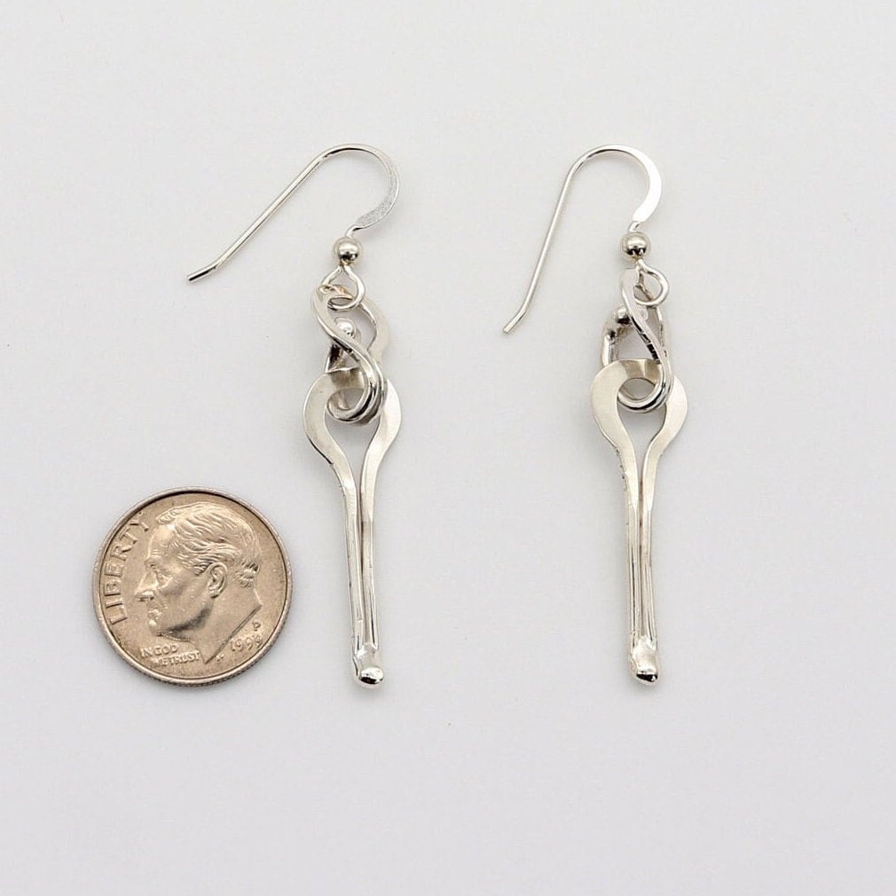 A handmade Argentium solid silver keyhole drop pair of earrings.  Finished with Argentium® Silver ear wires, shown next to U.S. dime for scale with a drop length of 1.5 inches against a white background.