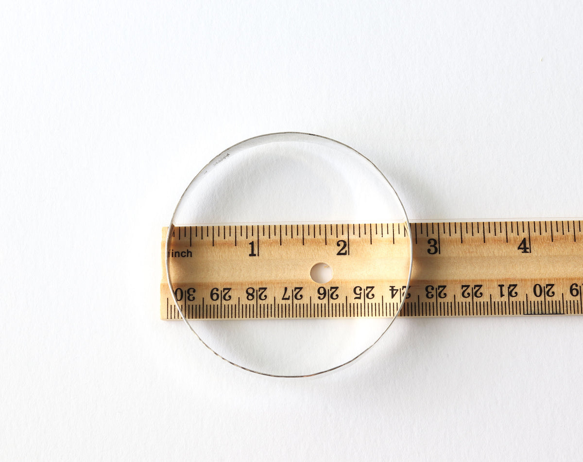 Handcrafted wide hammered Argentium 935 silver bangle bracelet on a white  background with wood ruler for size.