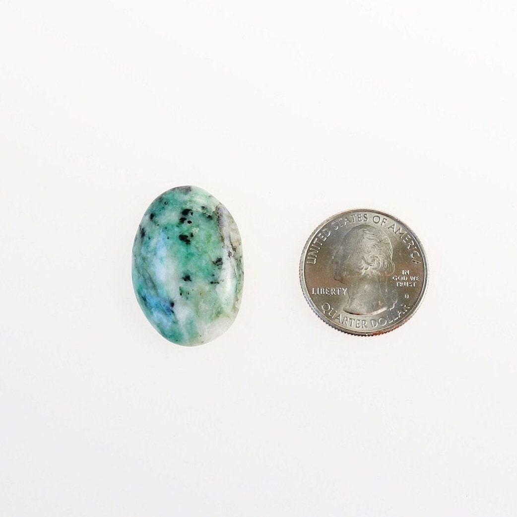 African Turquoise Jasper cabochon shown beside a U.S. quarter for size reference.  Shown on white background.