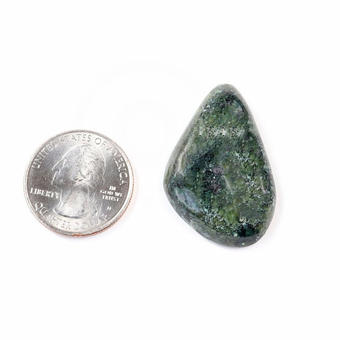 Hand-cut natural Moss Agate freeform cabochon with mottled green pattern shown next to a U.S. quarter against white background.