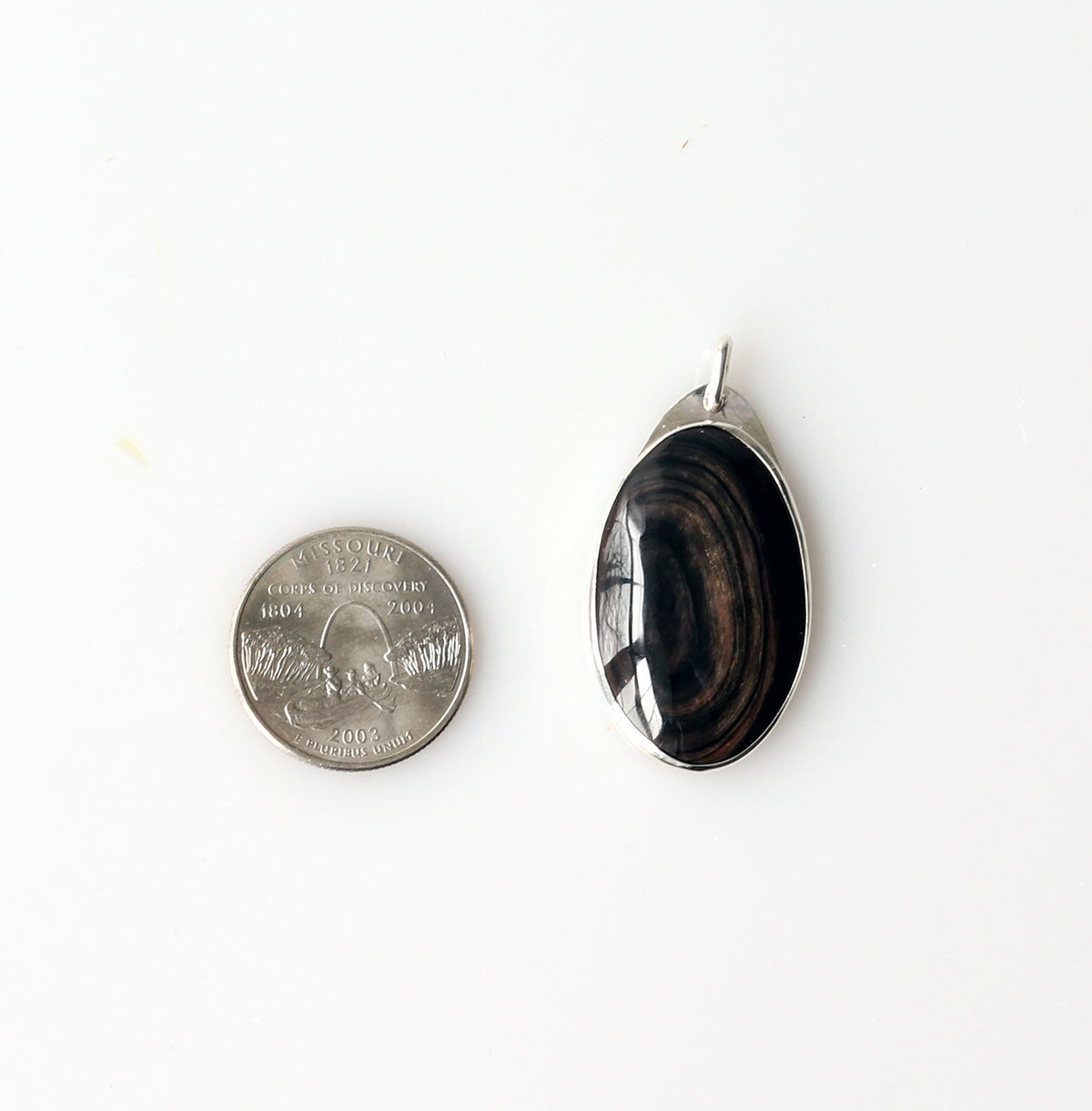 Natural Mahogany Obsidian pendant shown beside a U.S. quarter for size reference