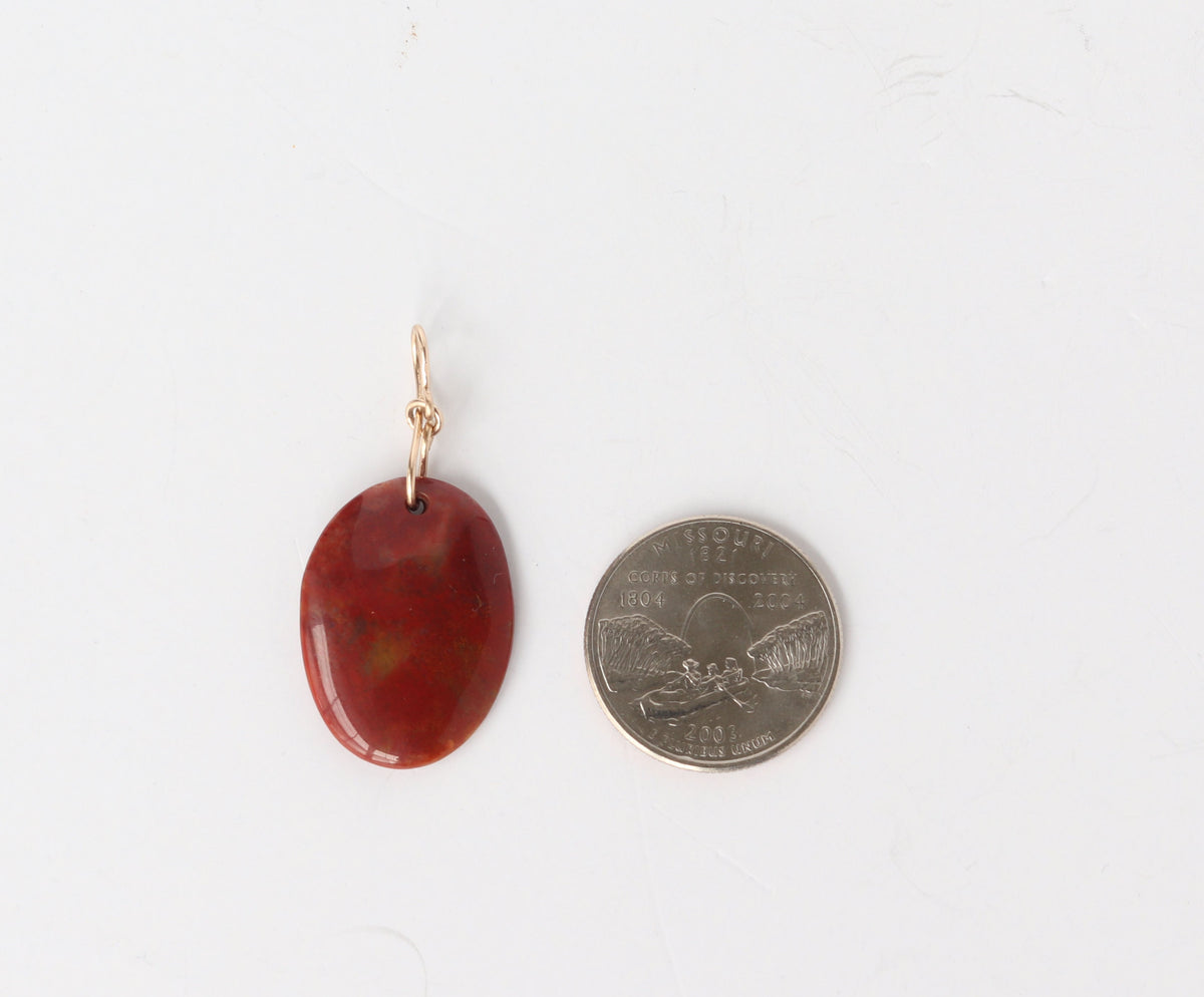 Sonoran sunrise pendant with dominate cuprite colors shown next to US quarter for scale against white background.